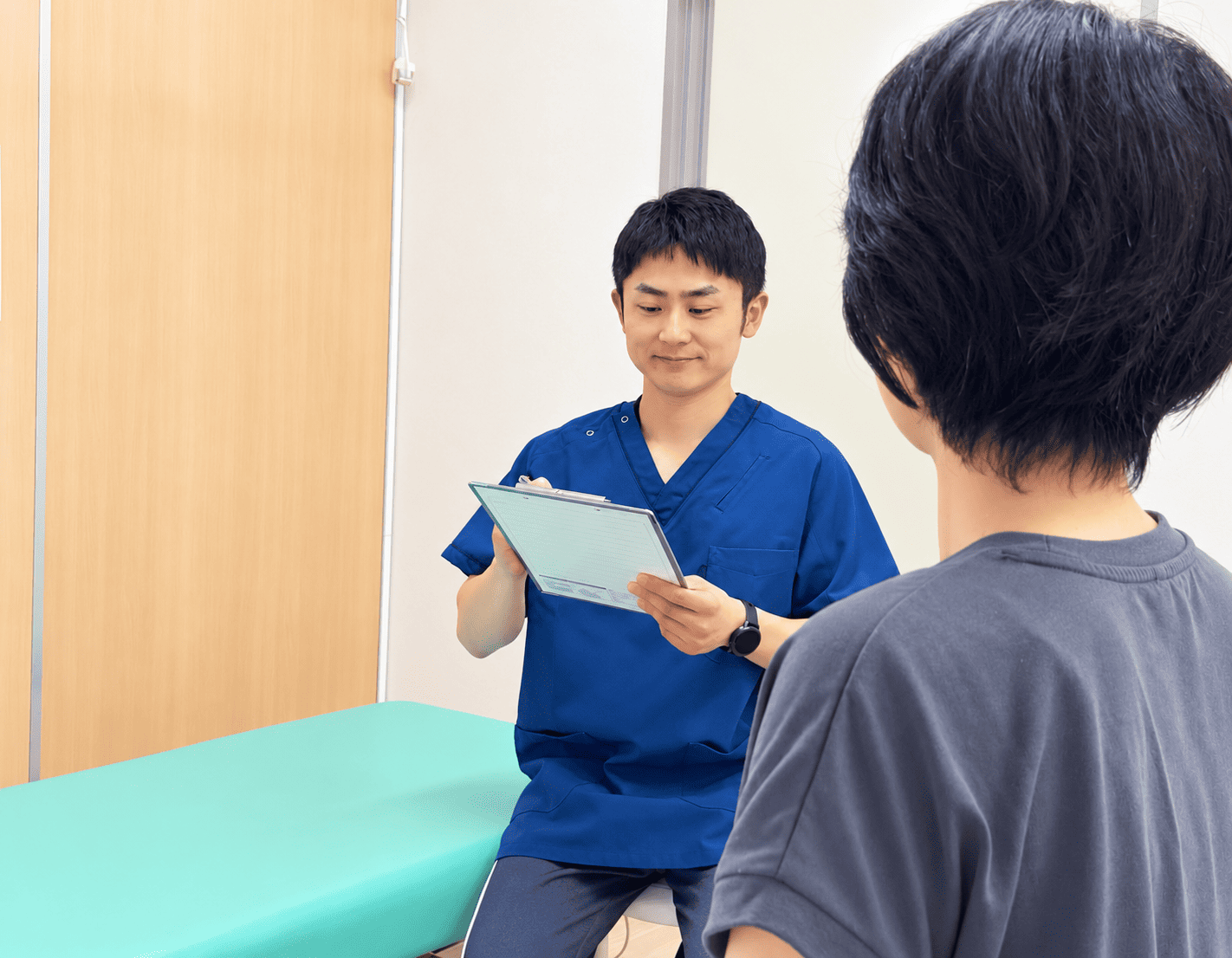 院内で患者様のお話を伺う施術者